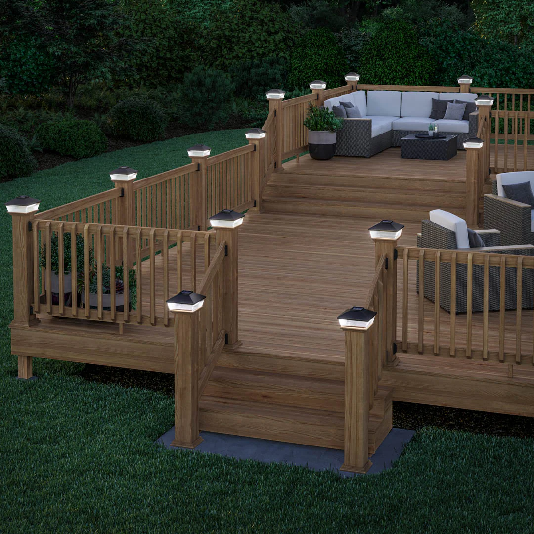 Solar-powered post cap on brown wooden deck with landscaped garden background, demonstrating ambient outdoor lighting