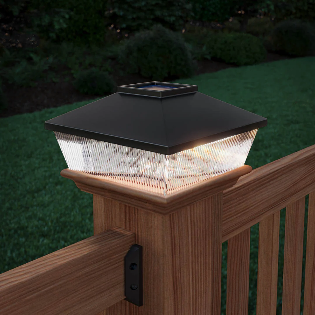 Solar post cap illuminating wooden deck railing at twilight, showcasing elegant outdoor lighting design