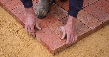 How do I stop polymeric sand from cracking or washing out after winter, and what should I do differently on install day?