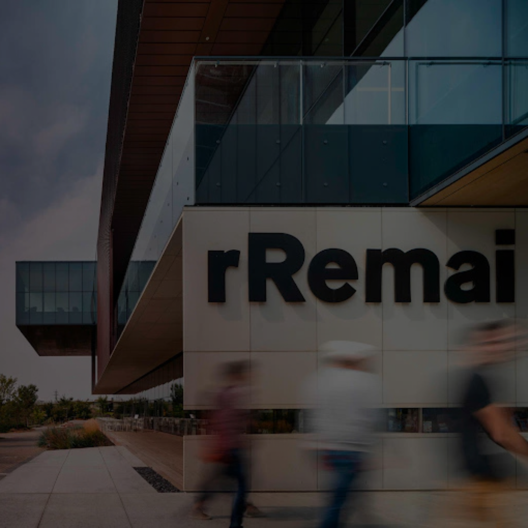 People walking past a modern building with 'rRemai' branding.