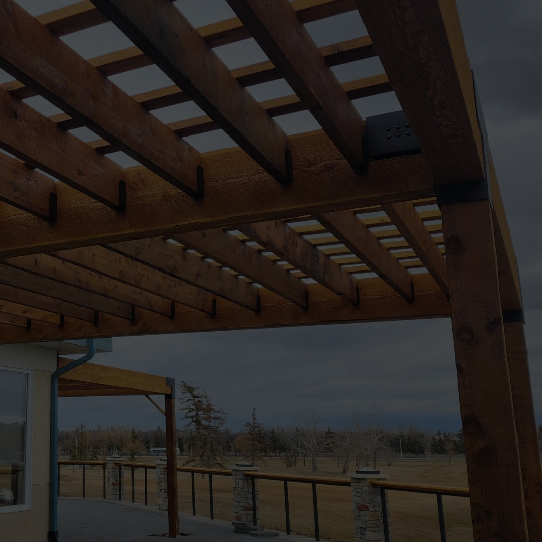 Wooden pergola structure with a view of trees and sky in the background